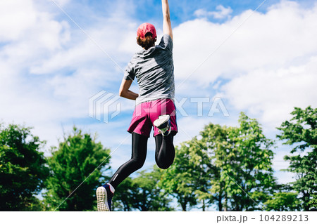 青空に向かってジャンプするスポーツ中の女性 青空に向かってジャンプするスポーツ中の女性 104289213
