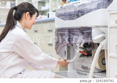 薬局・ドラッグストアで自動分包機を使って粉薬・調剤・処方箋を作る薬剤師 薬局・ドラッグストアで自動分包機を使って粉薬・調剤・処方箋を作る薬剤師 104289791