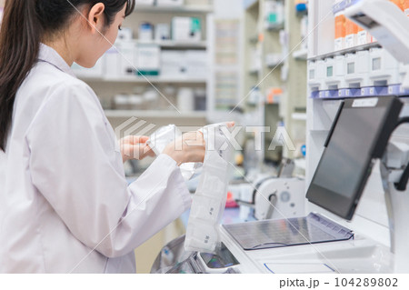 薬局・ドラッグストアで自動分包機を使って粉薬・調剤・処方箋を作る薬剤師 薬局・ドラッグストアで自動分包機を使って粉薬・調剤・処方箋を作る薬剤師 104289802
