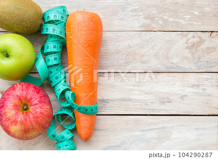 Top view carrot,apple and measuring tape on wood table background. Top view carrot,apple and measuring tape on wood table background. 104290287