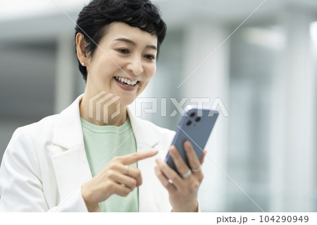 スマートフォンを操作するアラフィフのビジネスウーマン 104290949