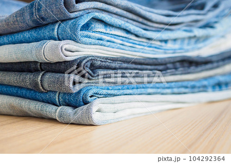 denim blue jeans stack on wood table background 104292364