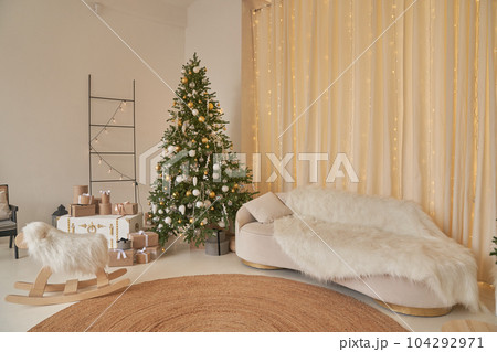 Christmas interior in the living room with beige sofa and Christmas trees with space to copy. High quality photo Christmas interior in the living room with beige sofa and Christmas trees with space to copy. High quality photo 104292971