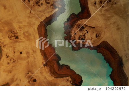 The texture of a wooden table covered with epoxy resin. Top view of a tree as a background with space to copy. High quality photo The texture of a wooden table covered with epoxy resin. Top view of a tree as a background with space to copy. High quality photo 104292972