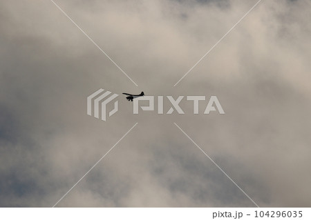 Small plane flying in the sky against dark clouds 104296035