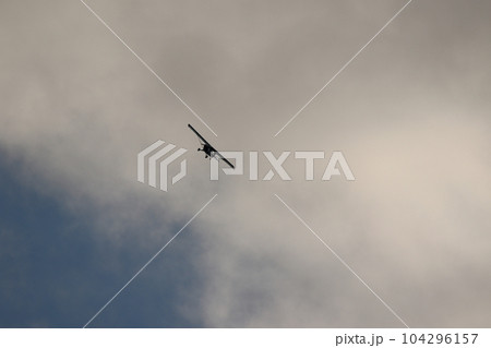 Small plane flying in the sky against dark clouds Small plane flying in the sky against dark clouds 104296157
