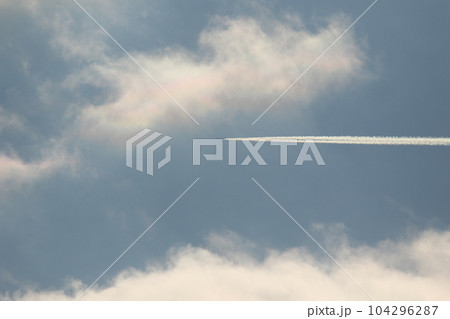 A plane and vapor trails in the sky 104296287