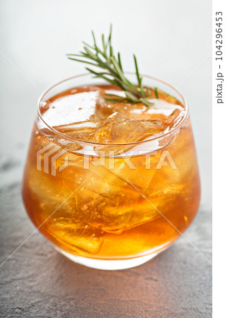 Old fashioned cocktail with ice and rosemary 104296453