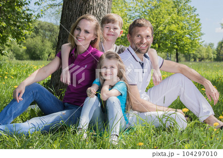 Family on grass in summer park Family on grass in summer park 104297010