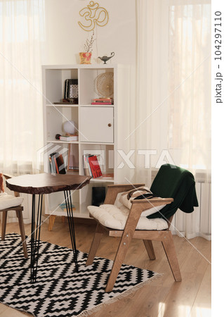 part of boho style living room with wooden coffee table and wooden armchair. vertical shot of cozy apartment 104297110