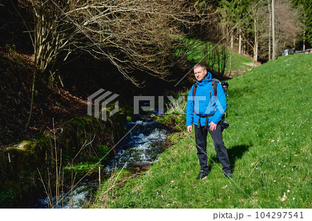 Man hiking at sunset mountains with heavy backpack Travel Lifestyle wanderlust adventure concept summer vacations outdoor alone into the wild. Hipster man traveler wanderer wearing travelling alone Man hiking at sunset mountains with heavy backpack Travel Lifestyle wanderlust adventure concept summer vacations outdoor alone into the wild. Hipster man traveler wanderer wearing travelling alone 104297541