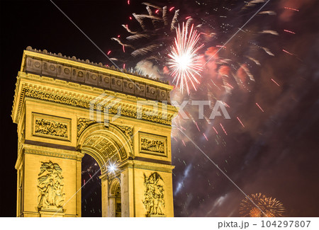 Celebratory colorful fireworks over the Arc de Triomphe, Paris, France. The walls of the arch are engraved with the names of 128 battles and names of 660 French military leaders (in French) 104297807
