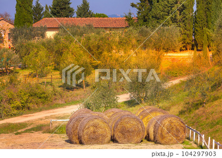 Tuscany landscape with farm and hay bales, Italy 104297903