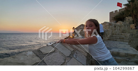 beautiful girl while walking along the sea promenade on the shore of the sea bay 104299867