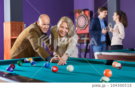 Relaxed people playing billiard and darts Relaxed people playing billiard and darts 104300518