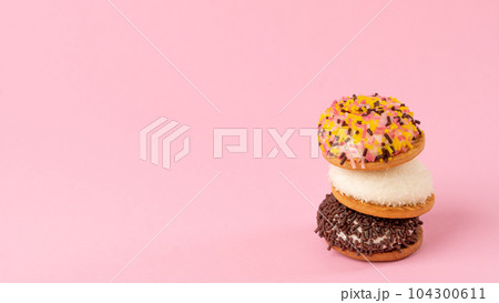 Cakes with decoration for confectionery - pink background with sweets, space for text 104300611