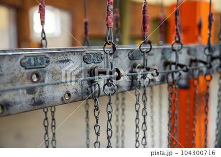 Close-up detail view old rusty chain lock row at miner's clothing room hall at ancient abandoned ore mine Rammelsberg Goslar Harz Germany. Unemployement and industry recession background Close-up detail view old rusty chain lock row at miner's clothing room hall at ancient abandoned ore mine Rammelsberg Goslar Harz Germany. Unemployement and industry recession background 104300716