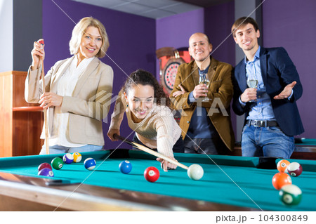 Group of friends playing billiards Group of friends playing billiards 104300849