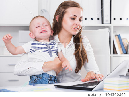 Girl is working on laptop while kid naughty 104300863