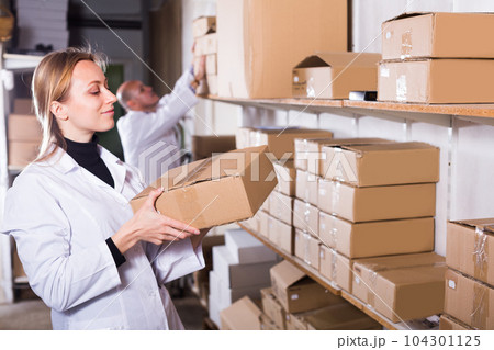 Woman worker standing with boxes at factory 104301125