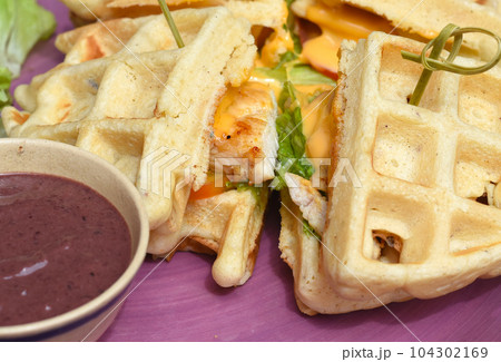 Belgium waffles with pan fried chicken on purple plate Belgium waffles with pan fried chicken on purple plate 104302169