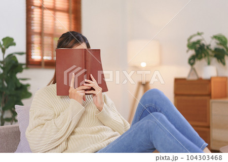 Relaxing time concept, Woman use holy bible covering face while reading book at modern home office Relaxing time concept, Woman use holy bible covering face while reading book at modern home office 104303468