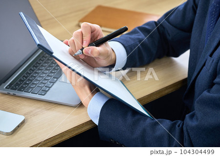 オフィスでアンケートに答えるスーツのビジネスマン（パーツカット） 104304499