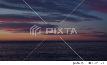 Beautiful sunset with purple clouds and flying birds over the sea Beautiful sunset with purple clouds and flying birds over the sea 104304874