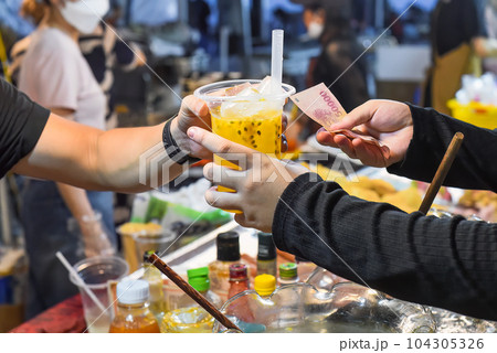 Vietnamese man sells passion fruit juice in plast cup in the night market in food festival 104305326