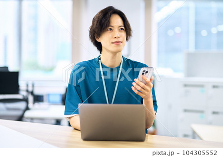 スマホを操作する若い男性エンジニア 104305552