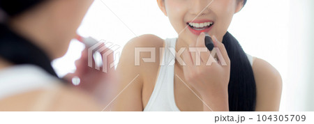 Beautiful young asian woman applying lipstick red on mouth, beauty girl looking facial at mirror. Beautiful young asian woman applying lipstick red on mouth, beauty girl looking facial at mirror. 104305709