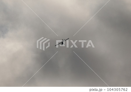 Small plane flying in the sky against dark clouds 104305762