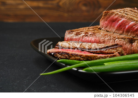 Closeup view of roasted beef steaks medium rare with fresh vegetables 104306545