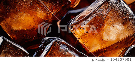 Cola with Ice. Close up of the ice cubes in cola water. Texture of carbonate drink with bubbles in glass. Cola soda and ice splashing fizzing or floating up to top of surface. Cold drink background. Cola with Ice. Close up of the ice cubes in cola water. Texture of carbonate drink with bubbles in glass. Cola soda and ice splashing fizzing or floating up to top of surface. Cold drink background. 104307901