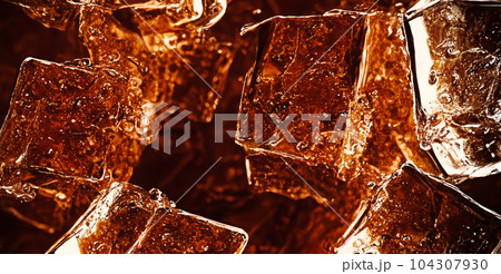 Cola with Ice. Close up of the ice cubes in cola water. Texture of carbonate drink with bubbles in glass. Cola soda and ice splashing fizzing or floating up to top of surface. Cold drink background. 104307930