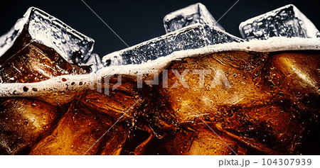 Cola with Ice. Close up of the ice cubes in cola water. Texture of carbonate drink with bubbles in glass. Cola soda and ice splashing fizzing or floating up to top of surface. Cold drink background. Cola with Ice. Close up of the ice cubes in cola water. Texture of carbonate drink with bubbles in glass. Cola soda and ice splashing fizzing or floating up to top of surface. Cold drink background. 104307939