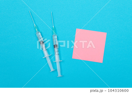 Vaccination or Revaccination Concept - Two Medical Syringe on Blue Table 104310600