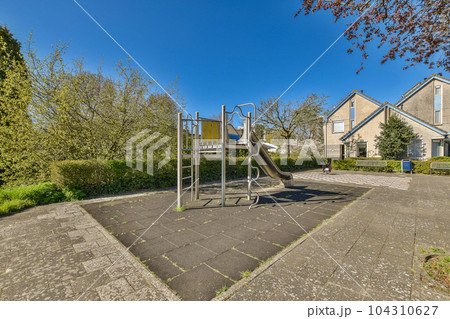 a playground in the middle of a residential area with lots of trees and bushes on either side of the street 104310627