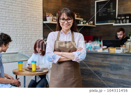Portrait of confident smiling middle aged woman coffee shop owner Portrait of confident smiling middle aged woman coffee shop owner 104311456