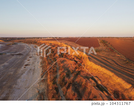 Dramatic towers and red sandstone cliffs cast purple shadows at sunset in Odessa 104311767