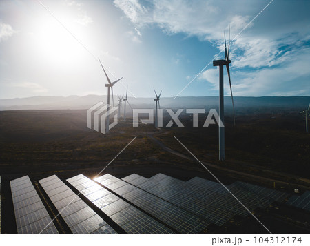 windmill and solar panel farm producing renewable energy with wind and sun 104312174