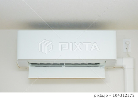 リビングの壁面に設置された省エネタイプのエアコン 104312375