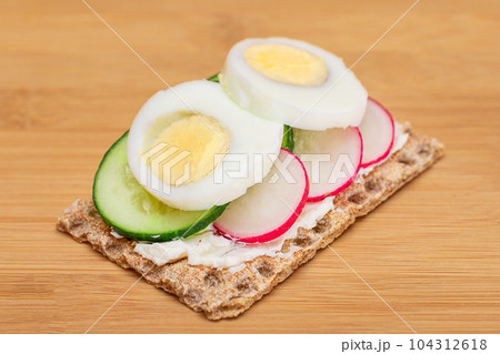 Whole Grain Crispbread with Fresh Cucumber, Egg, Cream Cheese and Radish 104312618