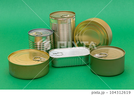 Unopened Tin Cans with Blank Edges on Green Background Unopened Tin Cans with Blank Edges on Green Background 104312619