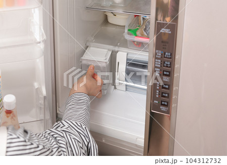 【冷蔵室から給水タンクを出す主婦】 104312732