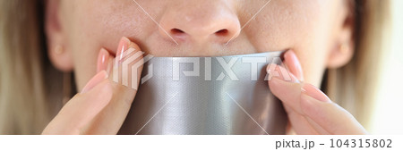 Young woman with duct tape sealed on mouth 104315802