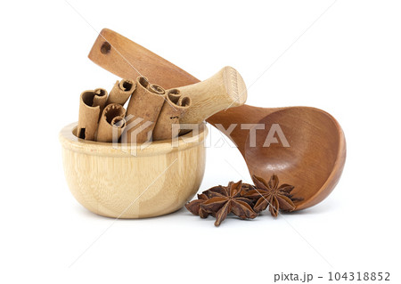 Mortar with cinnamon sticks and star anise on white Mortar with cinnamon sticks and star anise on white 104318852