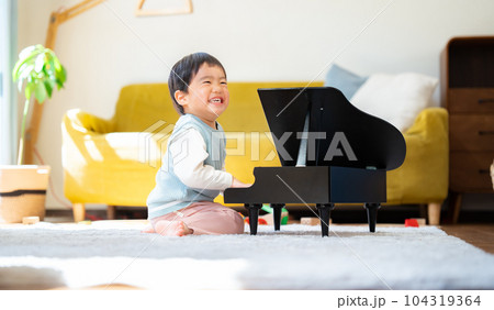 リビングでおもちゃのピアノを弾く3歳の男の子 104319364