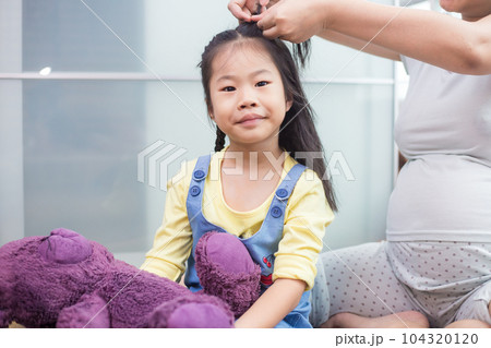 Little aian girl hair make up by mom in bedroom 104320120