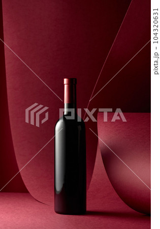 Bottle of red wine on a red background. Bottle of red wine on a red background. 104320631